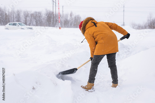 Man cleaning snow from sidewalk and using snow shovel. Winter season