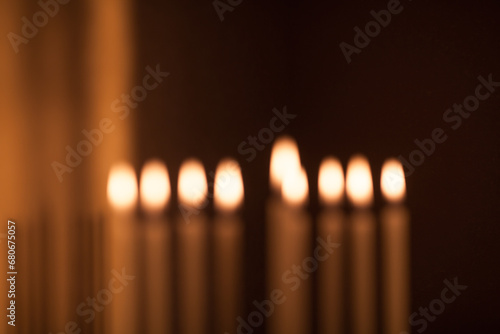 Hanukkah menorah, or hanukkiah with burning candles is out of focus. Jewish holiday Hanukkah background. Hanukkah lamp, nine-branched candelabrum is out of focus. Blurred background.