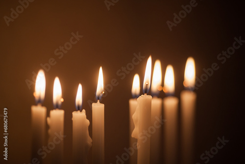 Closeup of Hanukkah menorah, or hanukkiah in the light of the sun at sunset for Jewish holiday Hanukkah. Hanukkah lamp, nine-branched candelabrum with burning candles.