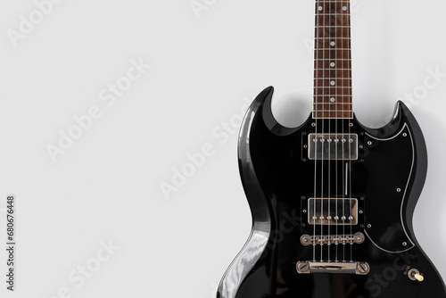 Old black gelectric guitar on white background. Musical wallpaper