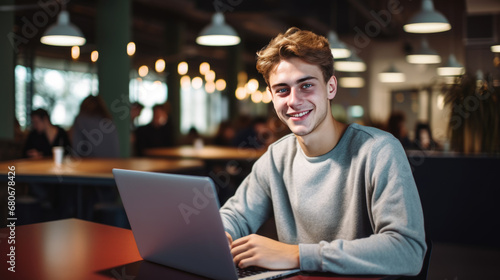 Smiling man working on a laptop in his office © MP Studio