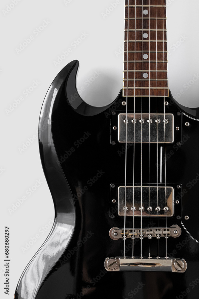 close-up photo of a black guitar on a white background