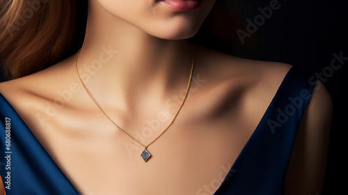 delicate golden necklace with a sapphire pendant worn by a model closeup isolated on black background photo