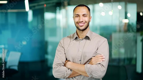 Portrait young adult businessman employee man in shirt smiling and looking at camera in office. Handsome mixed race african american business entrepreneur manager male posing calm friendly expression photo