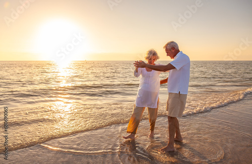 Happy Senior Old Retired Couple Walking Dancing Holding Hands on Beach at Sunset