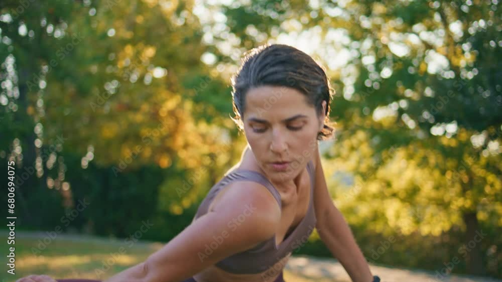 Flexible lady bending body at sun park closeup. Sportswoman stretching shoulders Flexible lady bending body at sun park closeup. Sportswoman stretching shoulders