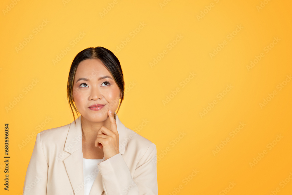 Pensive happy millennial korean lady manager in suit thinks, looking at free space Pensive happy millennial korean lady manager in suit thinks, looking at free space