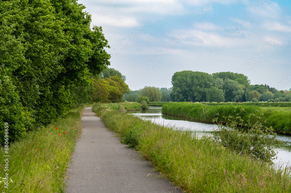 Biking path alongside the banks of the canal of Stekene, Flemish Region, Belgium