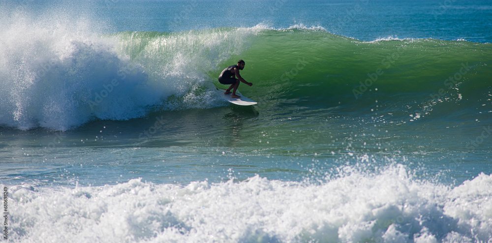 Surfer in action in the tubular waves of the Atlantic Ocean Surfer in action in the tubular waves of the Atlantic Ocean