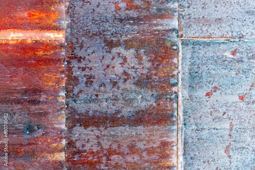 Rusted metal industrial background texture showing different amounts of weathering 