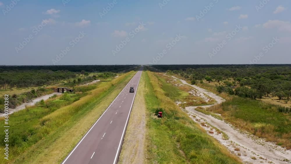 Car on road trip crossing an empty straight asphalt road. A desert highway Car on road trip crossing an empty straight asphalt road. A desert highway