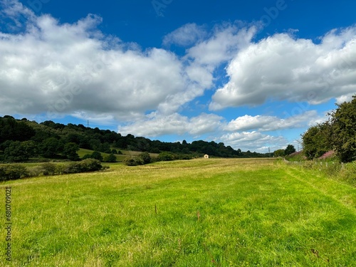Extensive landscape, with fields, wild plants, old trees, and a stone barn near, Keighley, UK