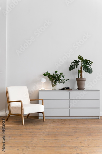 Fototapeta Naklejka Na Ścianę i Meble -  White armchair and commode with home decor in living room.