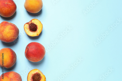 Delicious juicy peaches on light blue background, flat lay. Space for text