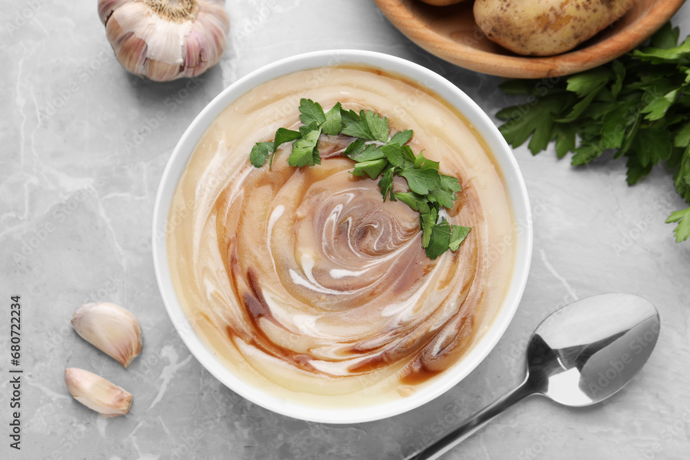 Delicious cream soup with soy sauce and parsley served on light grey marble table, flat lay Delicious cream soup with soy sauce and parsley served on light grey marble table, flat lay
