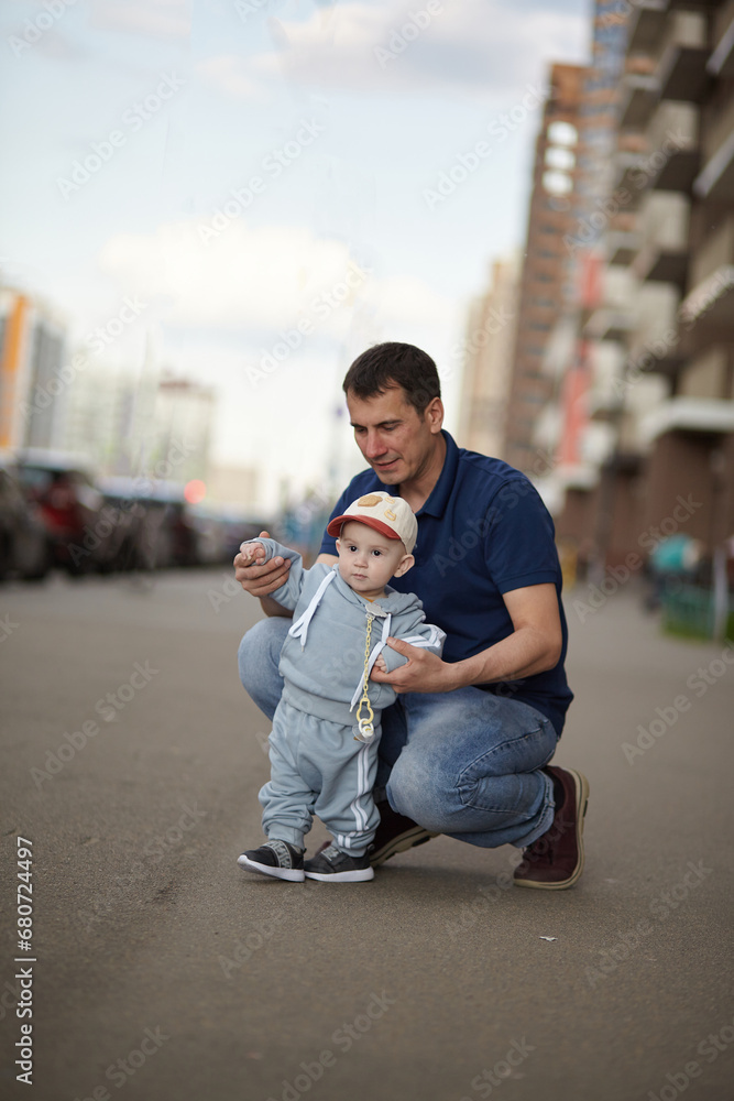 the first steps of the child are held by the father's hands. the first steps of the child are held by the father's hands.