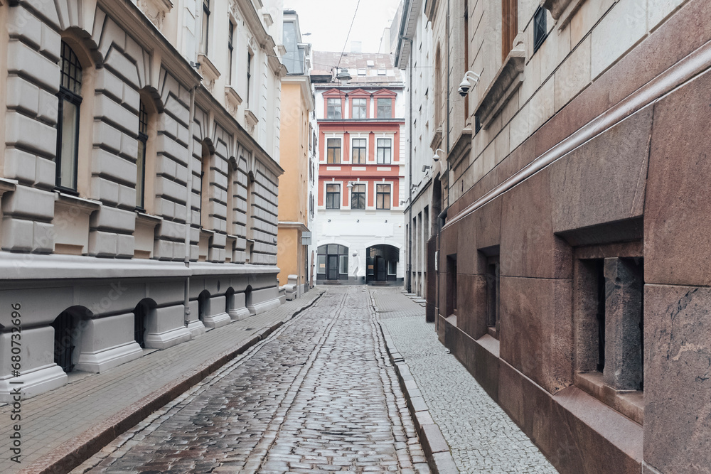 Empty street with cobble stone floor in the ancient neighbourhood in Riga, Latvia on a grey autumn day