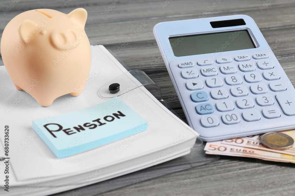 Calculator, piggy bank, euro banknotes, coins, folder and notes with word Pension on wooden table. Retirement concept Calculator, piggy bank, euro banknotes, coins, folder and notes with word Pension on wooden table. Retirement concept