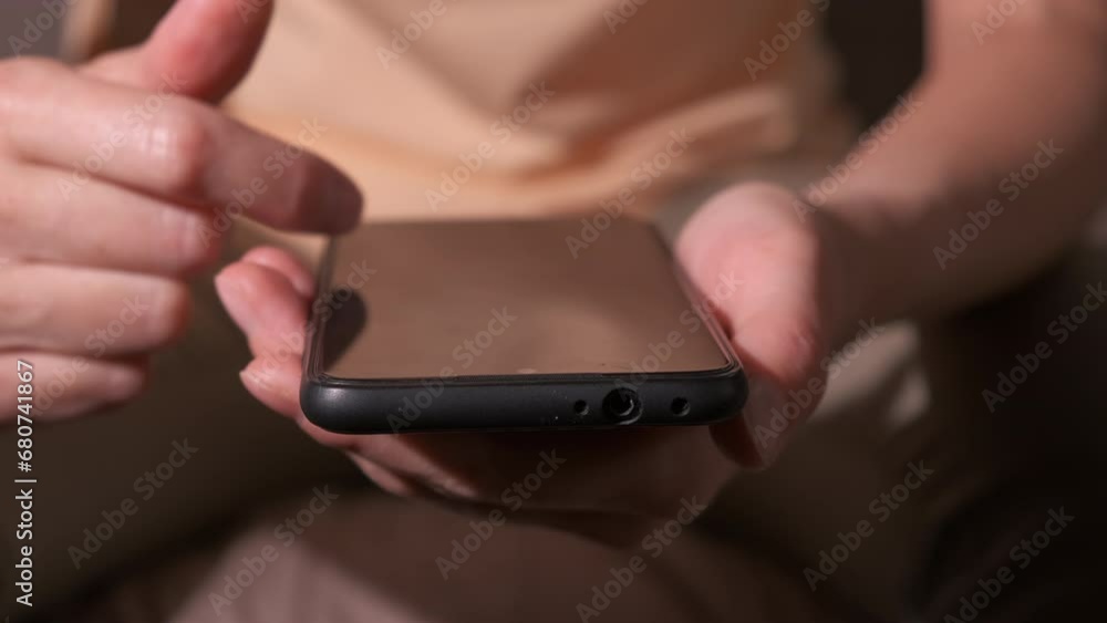 Lady hand click phone on sofa. A view of woman hand click something on her smartphone indoor. Lady hand click phone on sofa. A view of woman hand click something on her smartphone indoor.