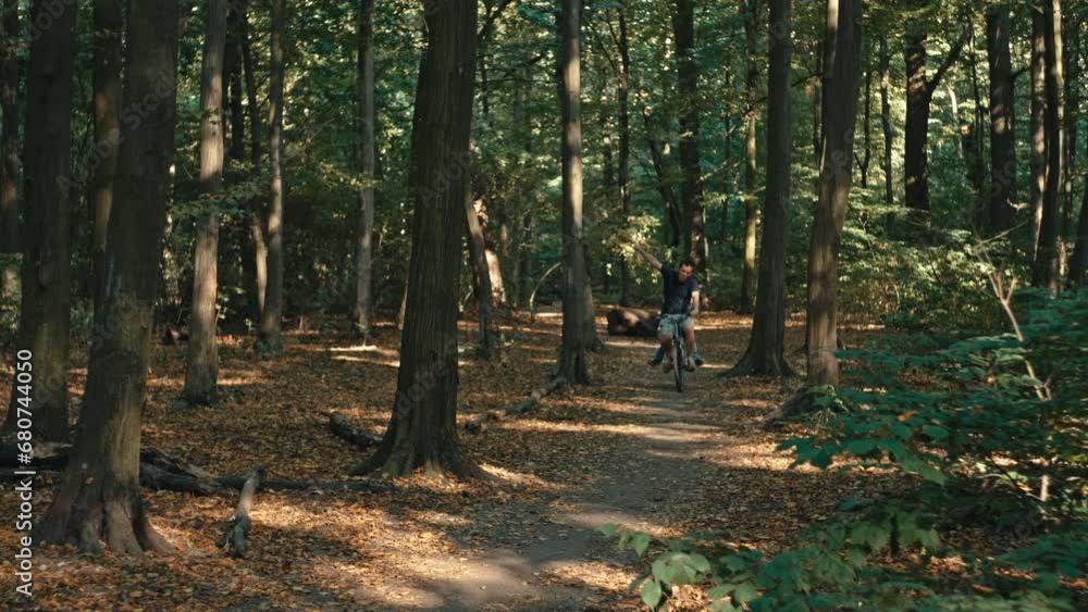 A man rides a bicycle in the forest. Active way of childhood, smiles, recreation in nature, riding a bike. High quality 4k footage A man rides a bicycle in the forest. Active way of childhood, smiles, recreation in nature, riding a bike. High quality 4k footage