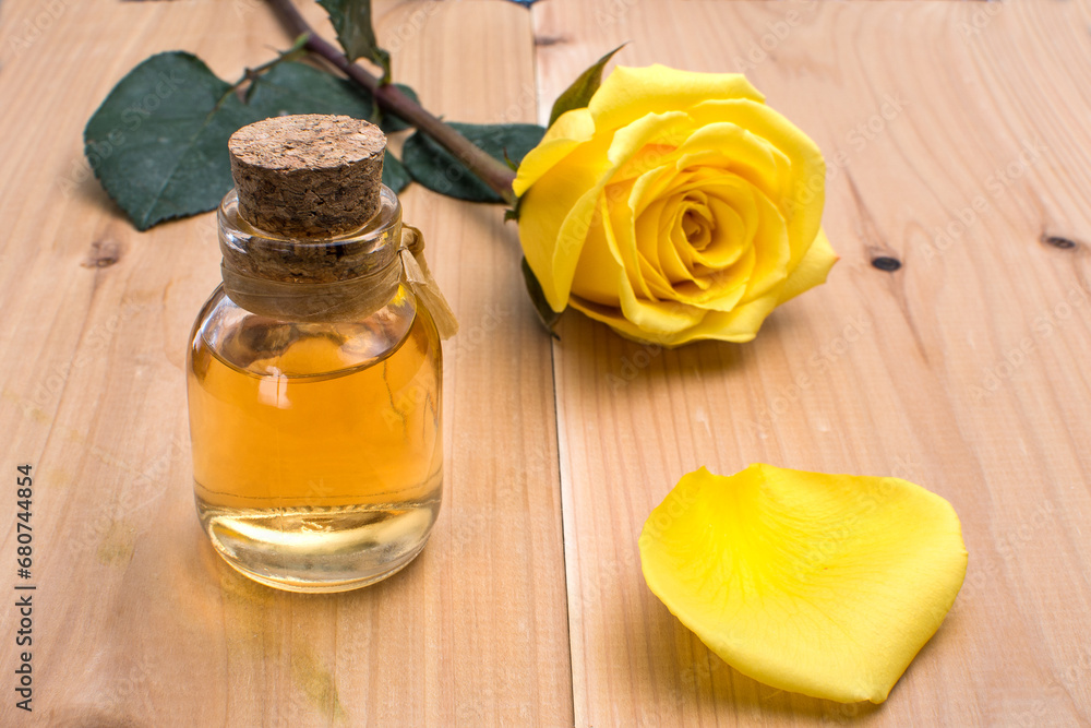yellow rose flower and essential oil in a glass bottle. spa and aromatherapy. close-up. yellow rose flower and essential oil in a glass bottle. spa and aromatherapy. close-up.
