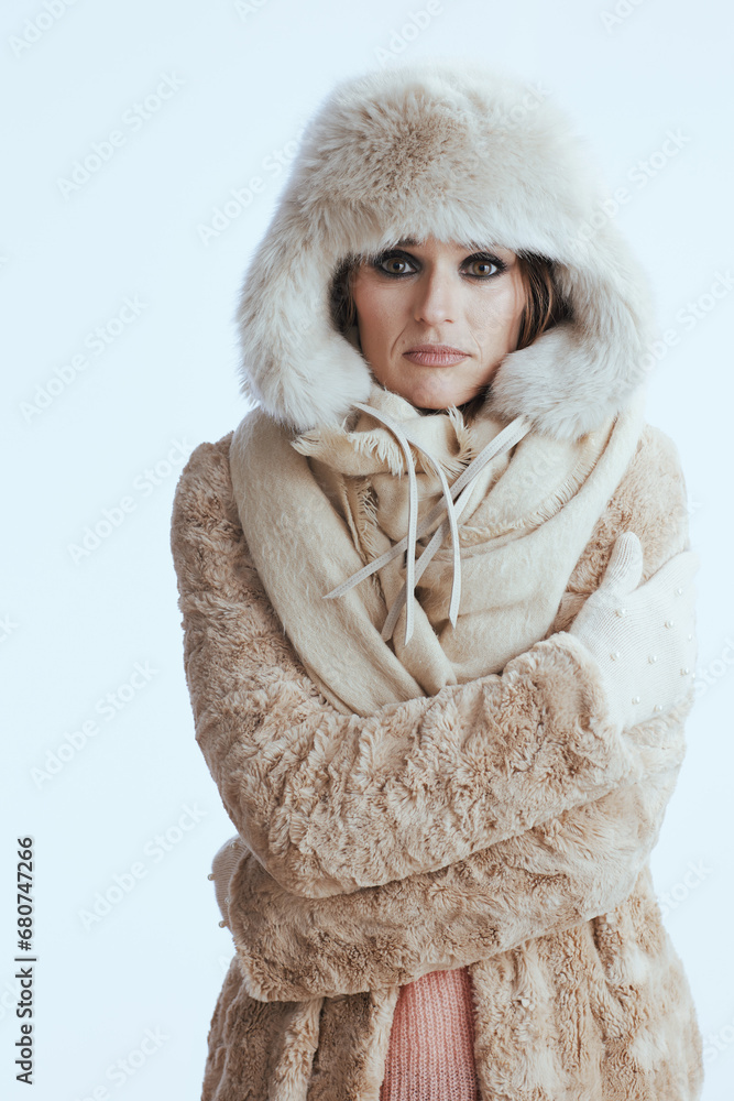 sad modern woman in winter coat and fur hat shivering on white sad modern woman in winter coat and fur hat shivering on white