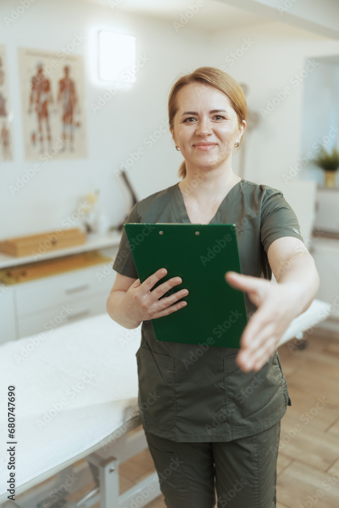 happy female medical massage therapist in massage cabinet happy female medical massage therapist in massage cabinet