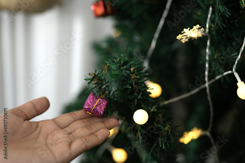 Christmas 2024 concept. Woman examines Christmas tree lights.