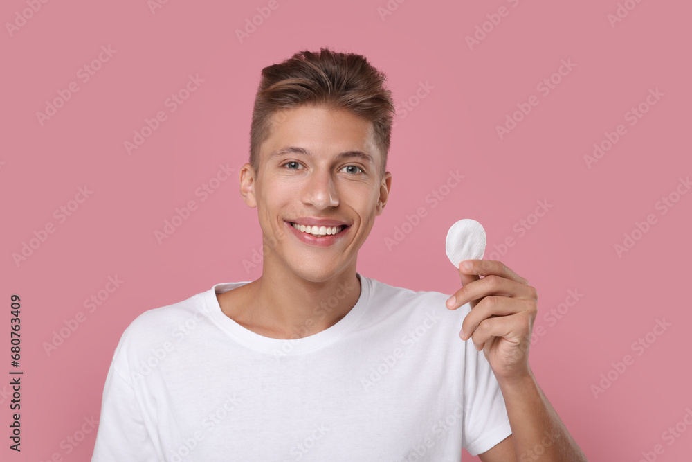 Handsome man with cotton pad on pink background Handsome man with cotton pad on pink background