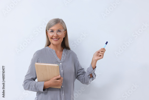 Foto Professor with notebook and marker giving lecture near whiteboard