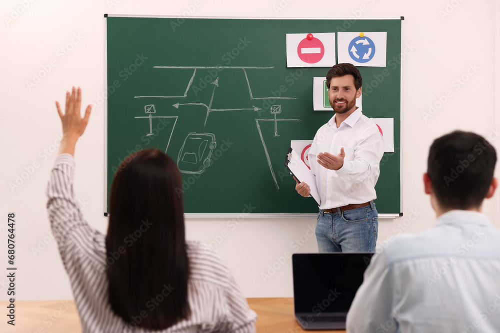 Teacher giving lesson to audience in driving school Teacher giving lesson to audience in driving school