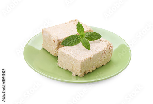 Plate with pieces of tasty halva and mint isolated on white