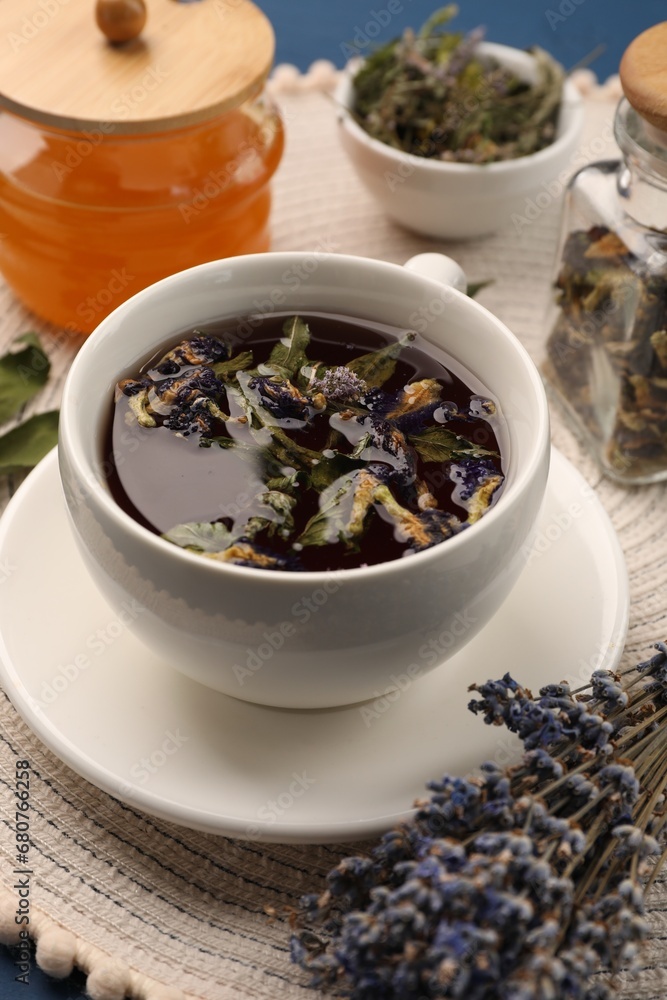 Aromatic tea with different dry herbs and honey on table, closeup Aromatic tea with different dry herbs and honey on table, closeup