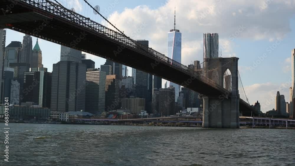 brooklyn bridge with water flowing in the hudson river, cars driving on the FDR drive (nyc skyline with one world trade center visible in the background) cityscape, skyscrapers, tourism, travel usa brooklyn bridge with water flowing in the hudson river, cars driving on the FDR drive (nyc skyline with one world trade center visible in the background) cityscape, skyscrapers, tourism, travel usa