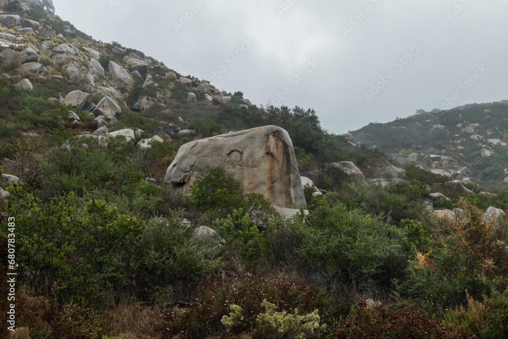 Strangely shaped large boulders on a side of a mountain at a remote location near Escondido, Southern California, on a rainy day
