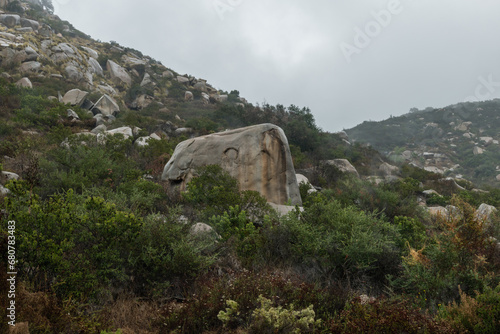 Strangely shaped large boulders on a side of a mountain at a remote location near Escondido, Southern California, on a rainy day photo