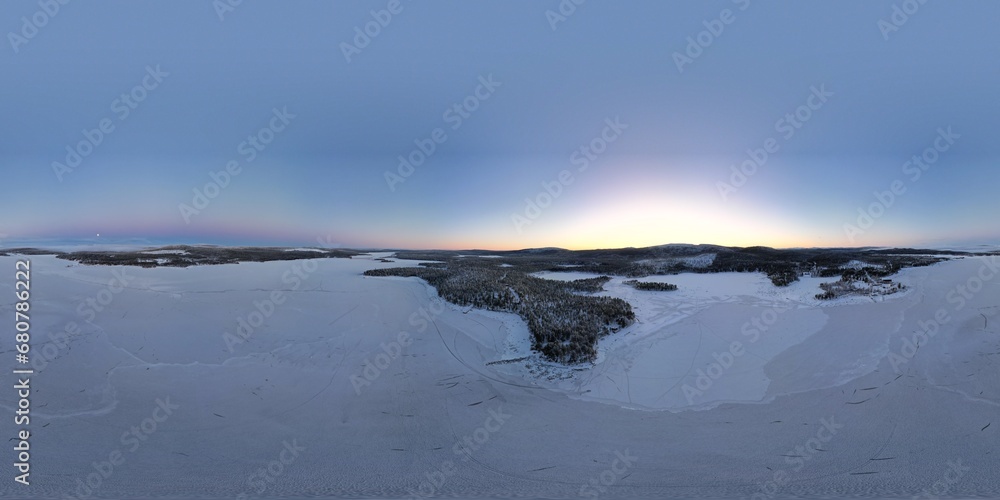 Fototapeta premium Dawn's soft light graces a vast snowy landscape near Kiruna's horizon.
