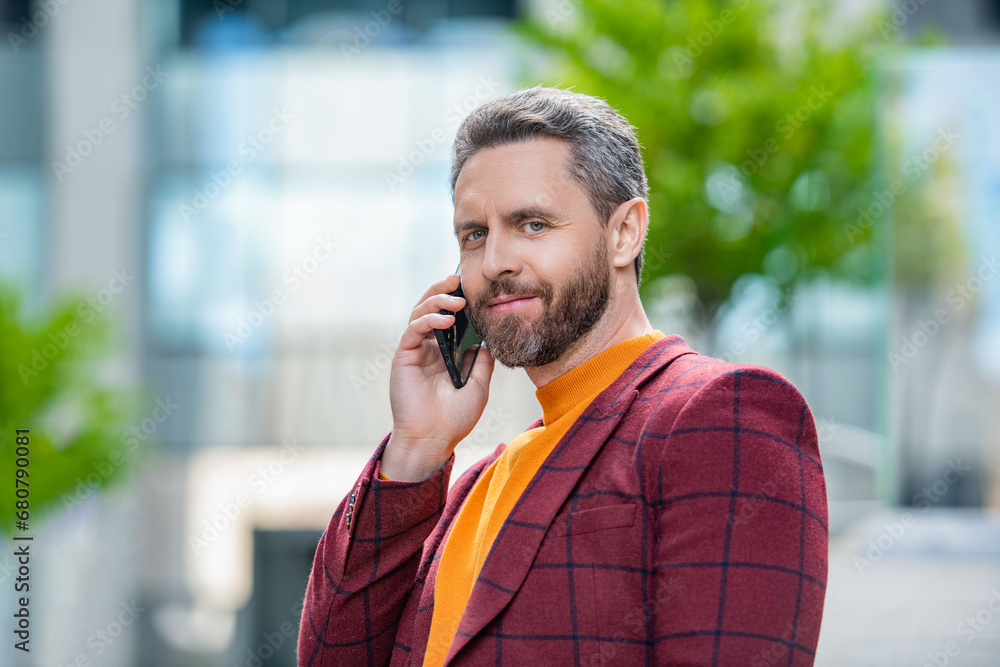 positive man has cellphone call outdoor. man having cellphone call in the street. positive man has cellphone call outdoor. man having cellphone call in the street.