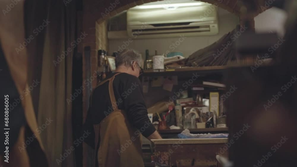 tracking shot in slow motion of craftsman while working in his workshop tracking shot in slow motion of craftsman while working in his workshop