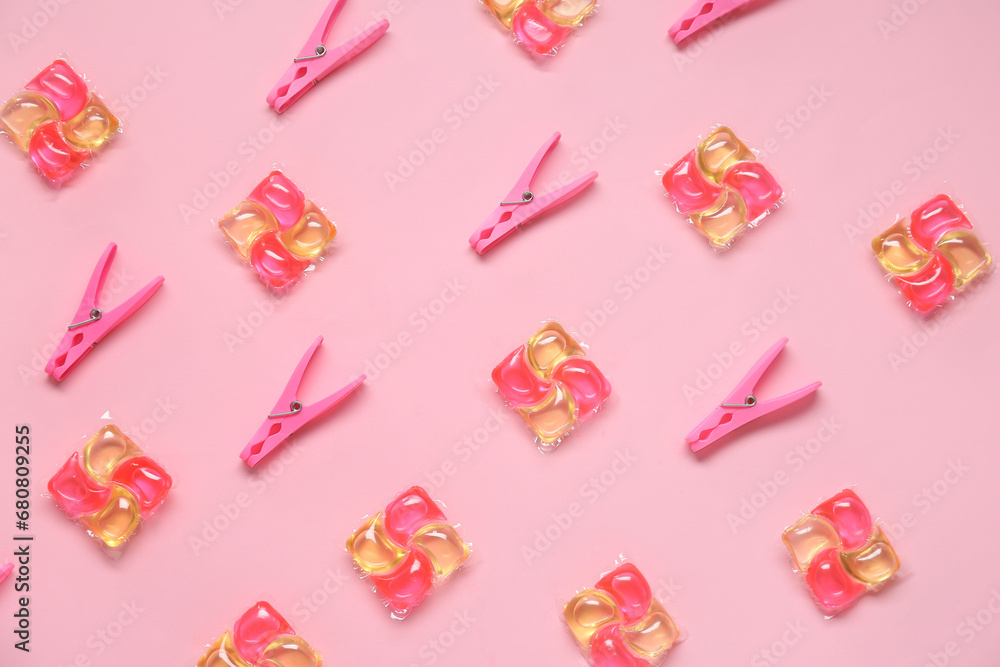 Composition with laundry detergent in capsules and clothespins on pink background Composition with laundry detergent in capsules and clothespins on pink background