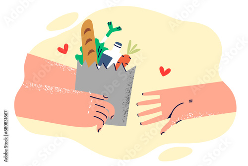 Paper bag with food in hands volunteer helping someone in need or delivering order from supermarket