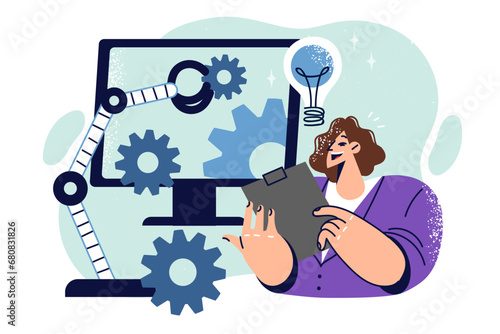 Woman studies production automation standing near monitor with gears and industrial arm manipulator