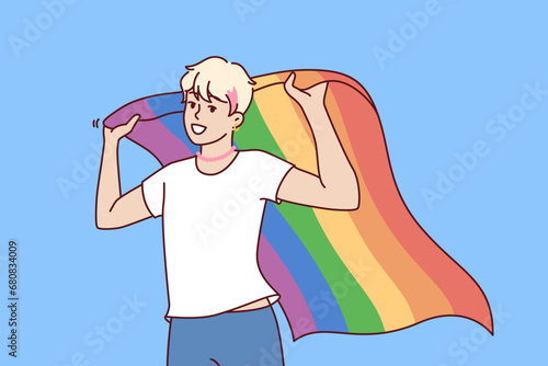 LGBT guy holds rainbow flag, openly announcing sexual orientation and participating in pride month. LGBT activist defends rights gays and lesbians and transgender people from LGBTq community