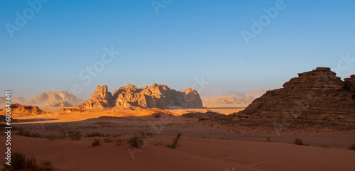 Jordan. Desert of Wadi Rum. Bizarre shapes of rocks in deserted desert. Landscape is similar to Martian landscapes. Sand is of beautiful pink color in rays of setting sun. Nature concept for design.