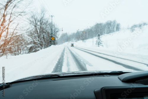 Beautiful snow road forest view during car driving in winter season. Winter travel, Road trip, Adventure, Exploring and Vacation concepts