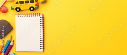 School notebook or notepad with pencil and toys on a yellow background. AI generated