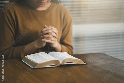 Pray worship and read the Bible God at the table in church on Sunday mornings. Christian women hold Hand prayer and confession at home photo