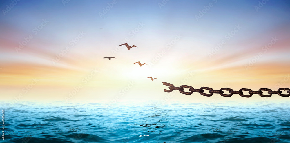 Silhouettes of broken chain and birds flying in blue sky - obrazy, fototapety, plakaty 