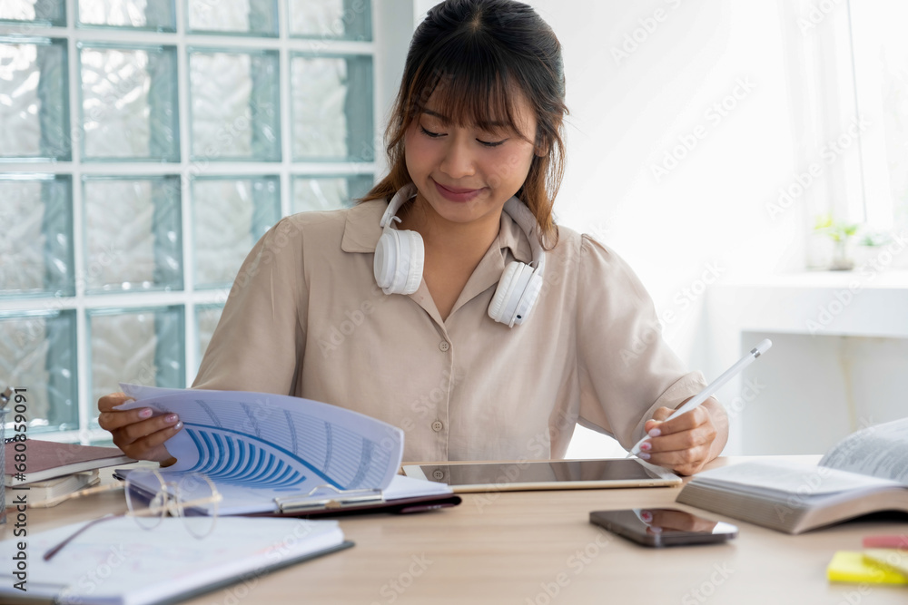 Young student studying indoor using tablet. Young student studying indoor using tablet.