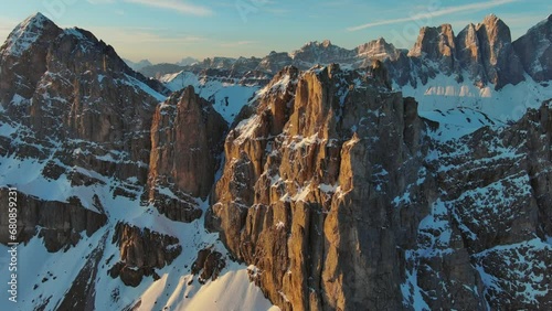 Aerial around view of amazing rocky mountains in snow at sunrise, Dolomites, Italy, 4k photo